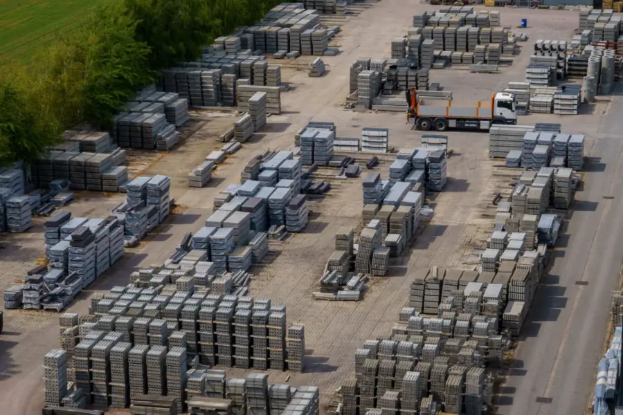 Aerial view of a storage yard full of pallets of concrete pavers, illustrating material costs for a driveway in Amsterdam