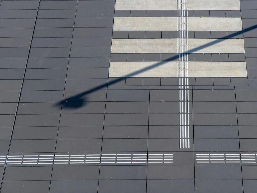 Large-format dark tiles with light bands seen from above, an example of a crisp tile layout for patios in Amsterdam